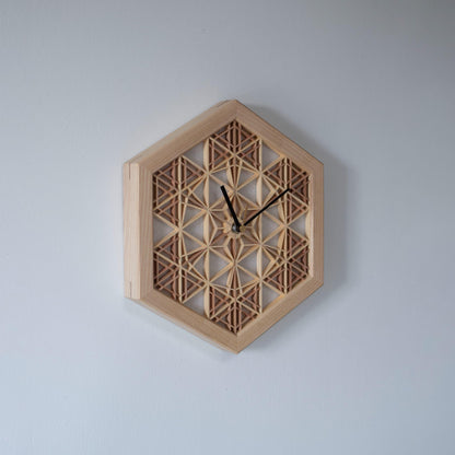 A kumiko clock hanging on a wall, viewed from the left side. The intricate wooden latticework is a testament to traditional Japanese craftsmanship.