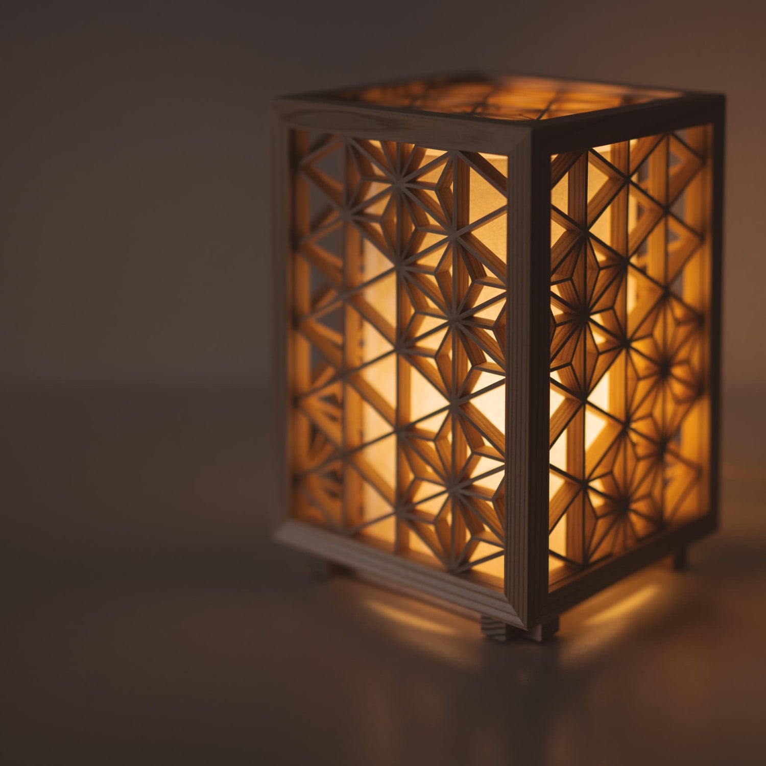 Small Japanese kumiko lamp meticulously handcrafted using the 1400-year-old "kumiko" technique, assembling 360 pieces of premium Akita cedar into a mesmerizing cubic form.