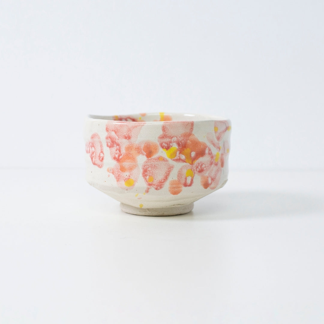 Handcrafted Japanese matcha bowl "Flower" with red-yellow glaze, perfect for tea or decor.