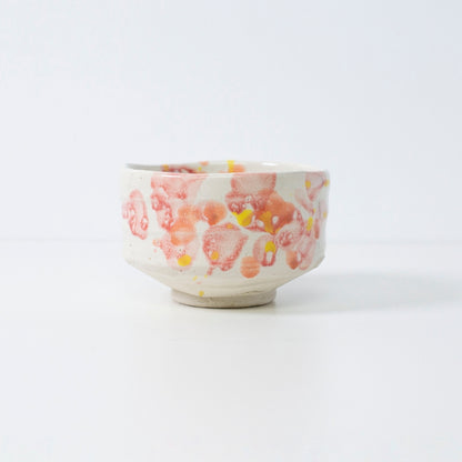 Handcrafted Japanese matcha bowl "Flower" with red-yellow glaze, perfect for tea or decor.