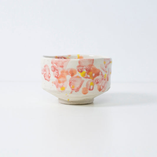 Handcrafted Japanese matcha bowl "Flower" with red-yellow glaze, perfect for tea or decor.