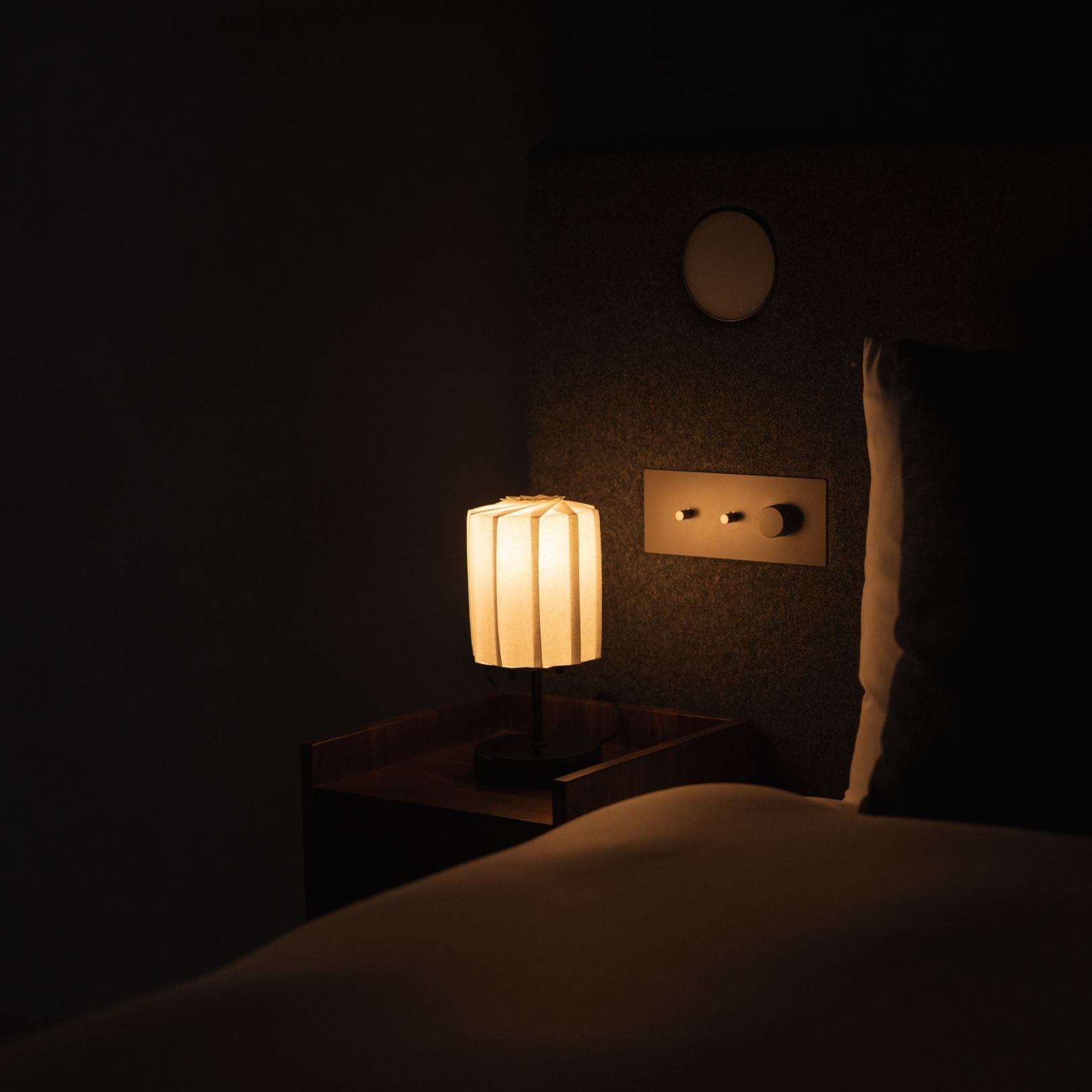 Japanese Paper Table Lamp "Flower of Light tutu with Stand" lit on a wooden bedside table
