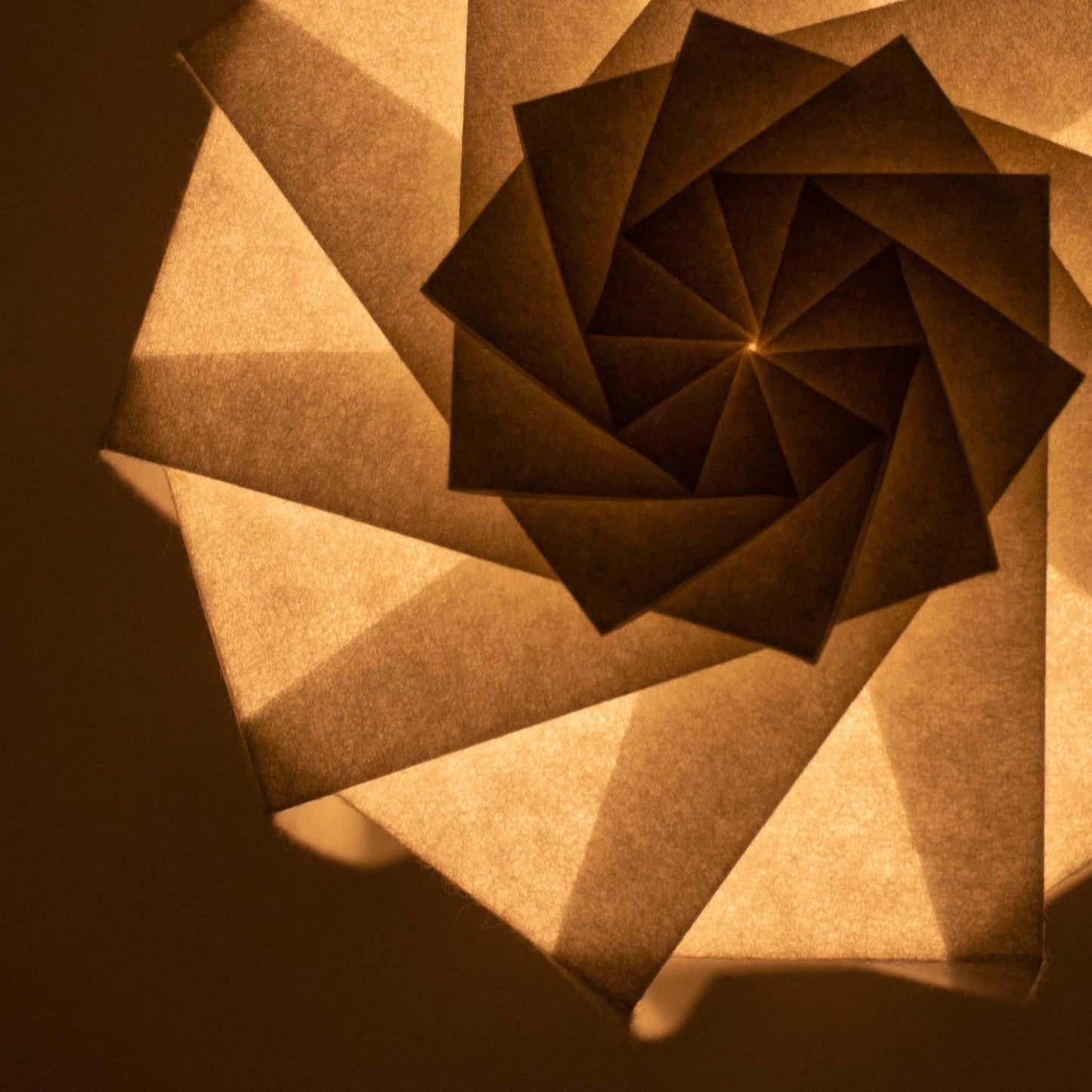 Frameless Japanese table lamp crafted with traditional Kyo-hyogu and origami techniques, featuring a unique illuminated origami pattern, placed on a table at night.