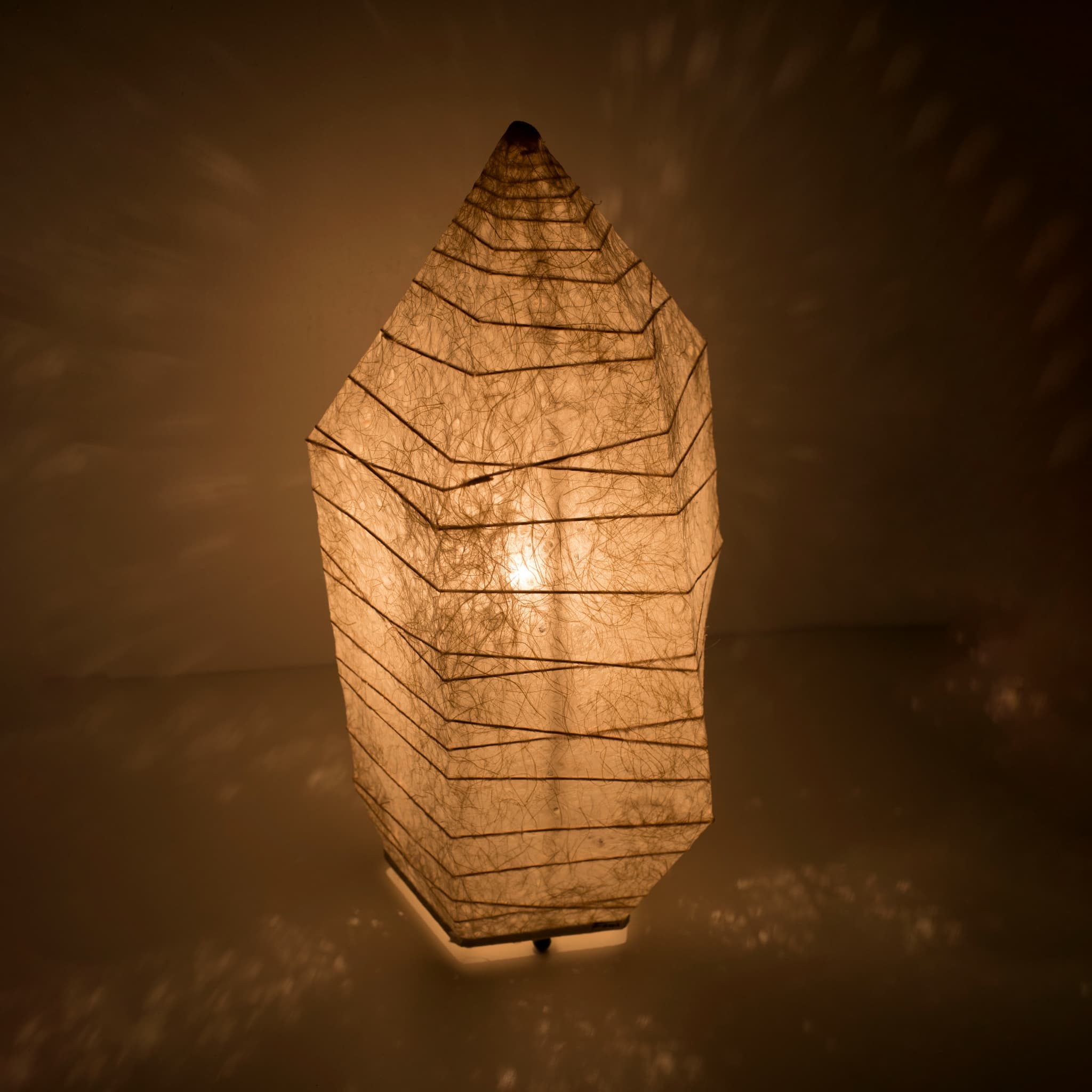 A Japanese lamp made from washi paper with ice stone design on brown background.