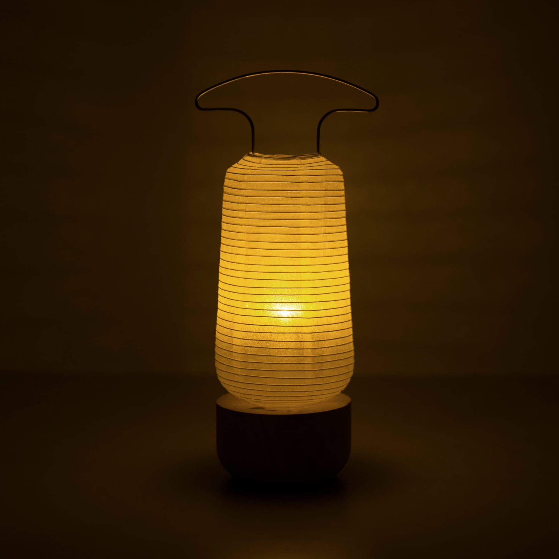 Traditional Japanese paper lantern glowing warmly in a dark room