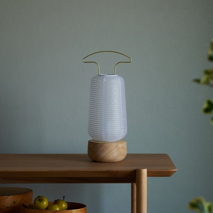 A traditional Japanese paper lantern on a wooden desk