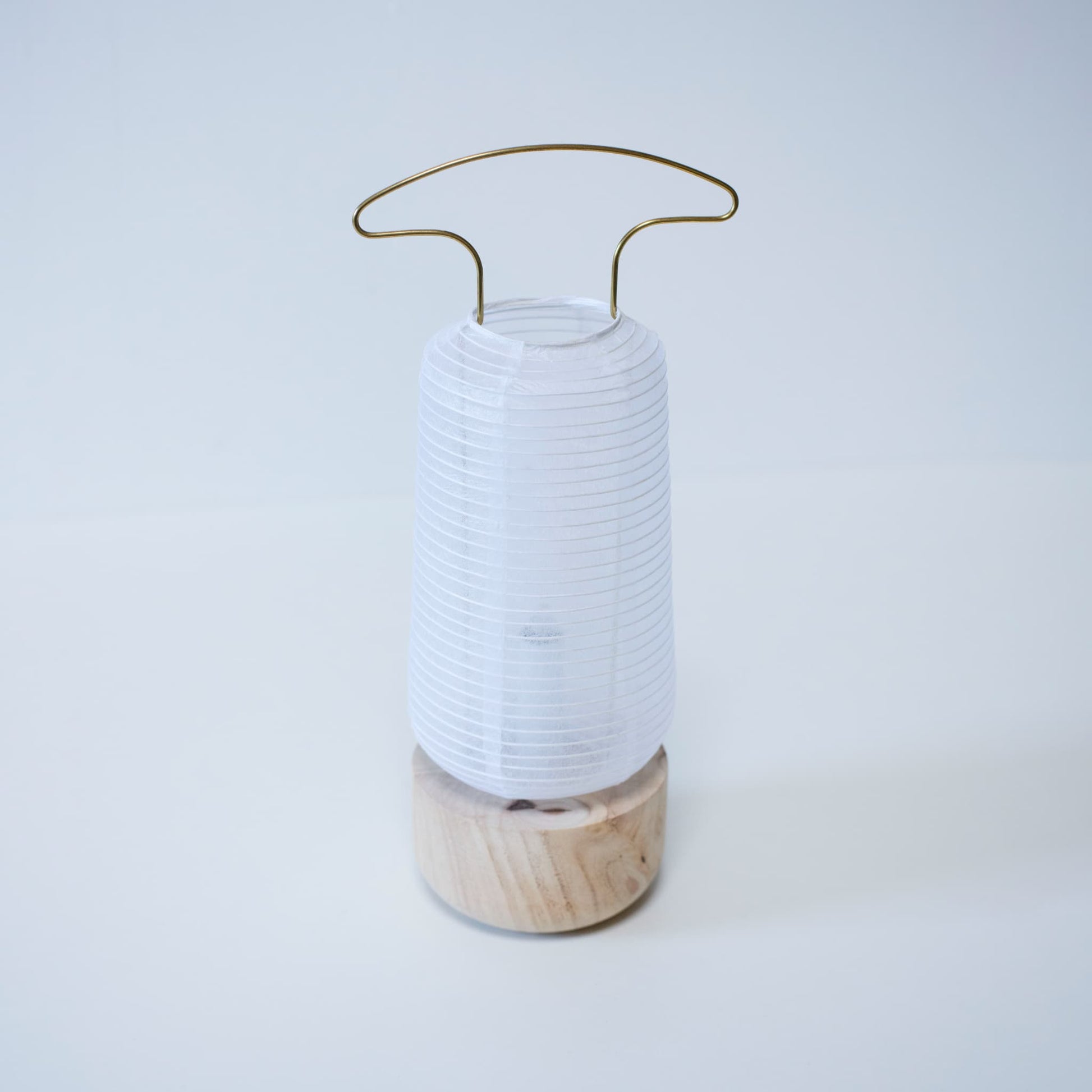 A traditional Japanese paper lantern with a background of bright white wallpaper