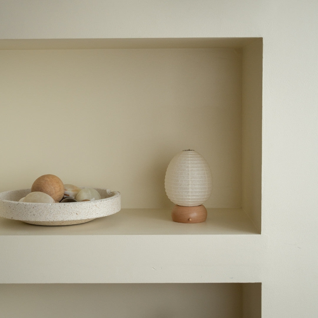 Japanese Paper Table Lamp "Mini Egg" on a white shelf in Japandi style living room – Stylish paper lamp for side table