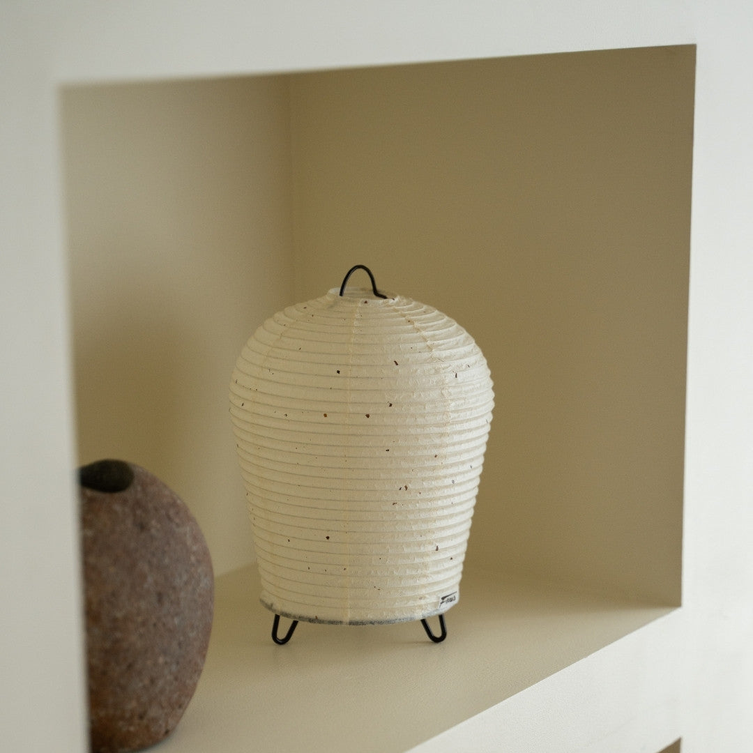 Japanese Paper Table Lamp "PAPERSON 01" on a white shelf in Japandi style living room – Unique paper table lamp for living room