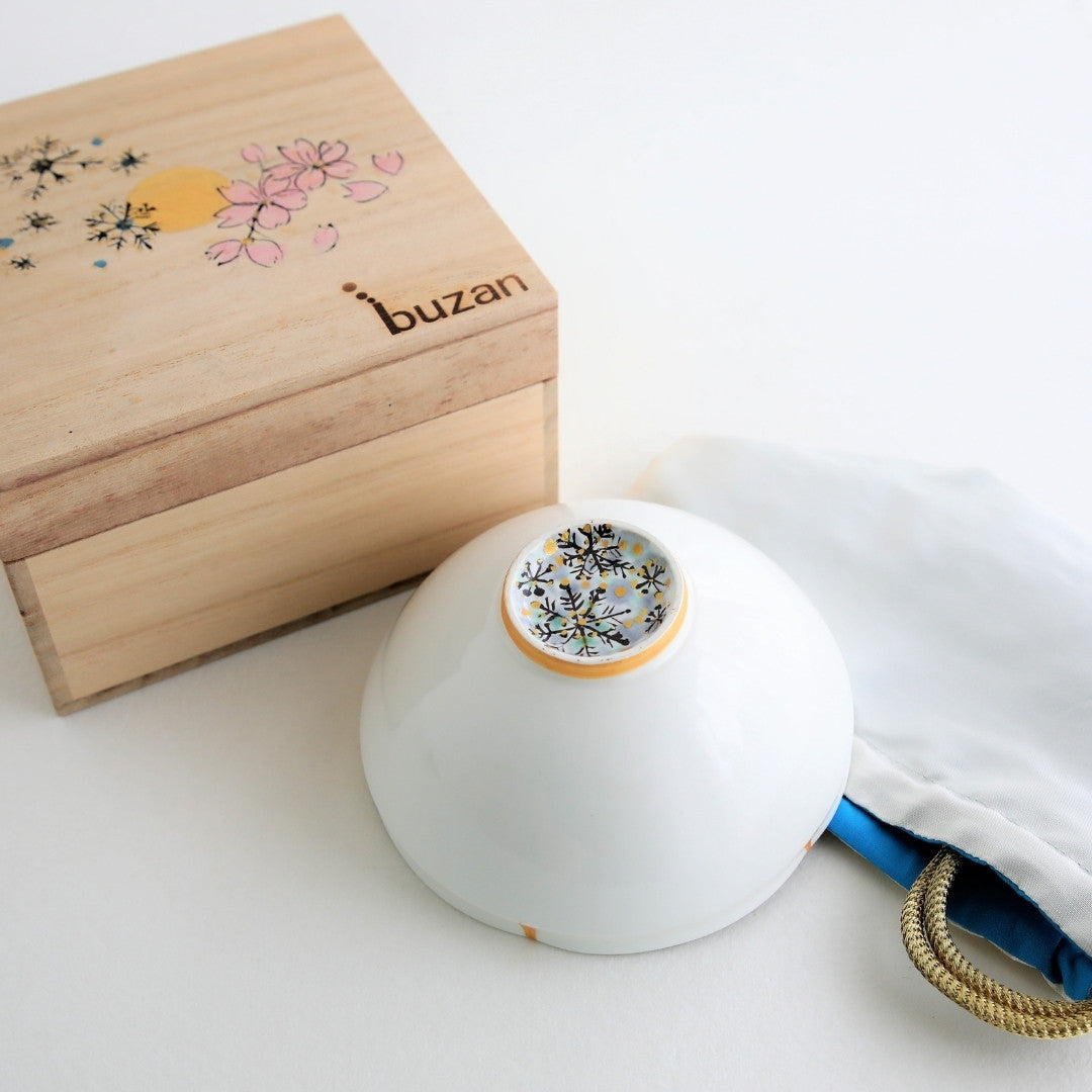 A handcrafted Japanese matcha bowl “Waraku” Snow made by Buzan Kiln, featuring delicate snowflake patterns and paired with a hand-painted wooden gift box.