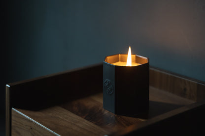 A Japanese scented candle on a bedside table