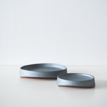 Two Japanese iron-color plates on a white table