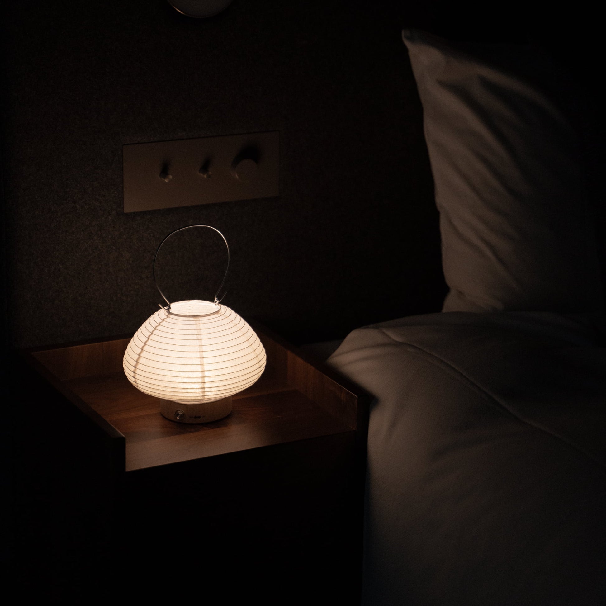 Japanese table lamp on a bedside table in a Japandi bedroom. 