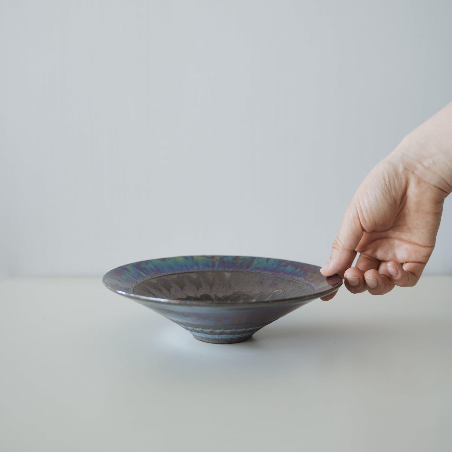 Hand holding Kintsugi Bowl "Blue Rose Nebula", showing its size and how it fits in the hand