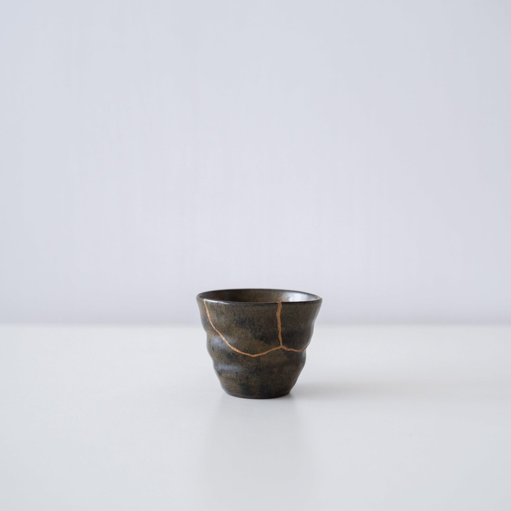 Side view of Kintsugi Sake Cup "Thunder Moss" in a white background