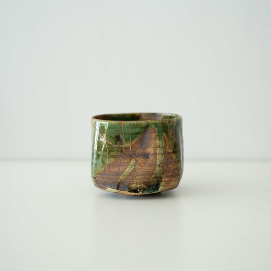 Side view of Kintsugi Tea Bowl "Valley Oribe" in a white background
