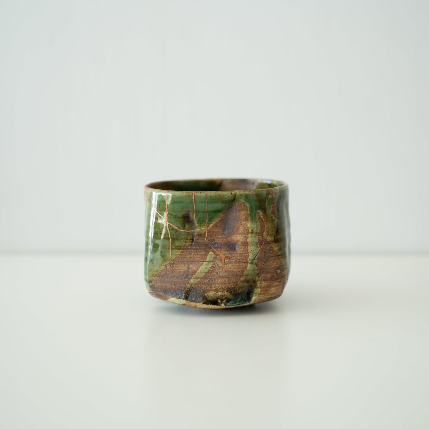 Side view of Kintsugi Tea Bowl "Valley Oribe" in a white background