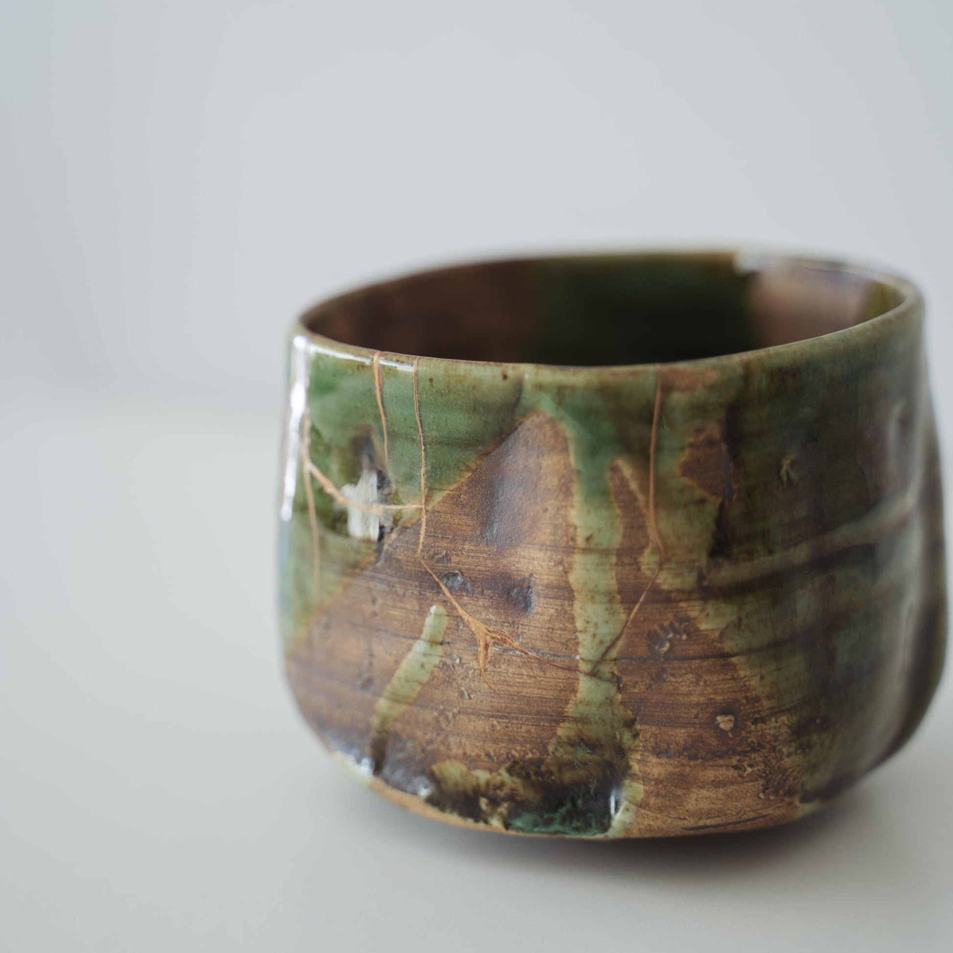 Close-up of Kintsugi Tea Bowl "Valley Oribe" side, highlighting the intricate Kintsugi repairs