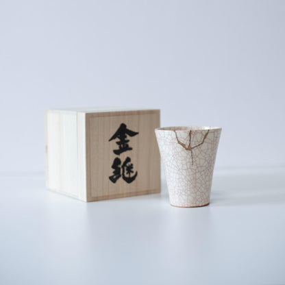 Kintsugi repaired white cup and paulownia wood box gift set, symbolizing the Japanese aesthetic of finding beauty in imperfection.