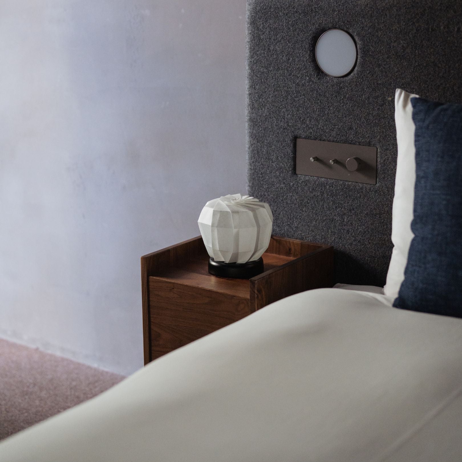 Japanese Paper Table Lamp "Flower of Light maru M" on a wooden bedside table