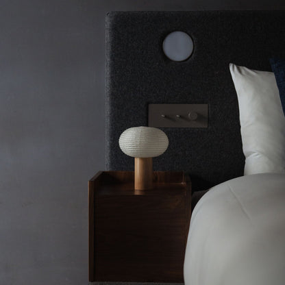 Japanese Paper Table Lamp "TORCHIN OVAL" on a bedside table in a Japandi bedroom