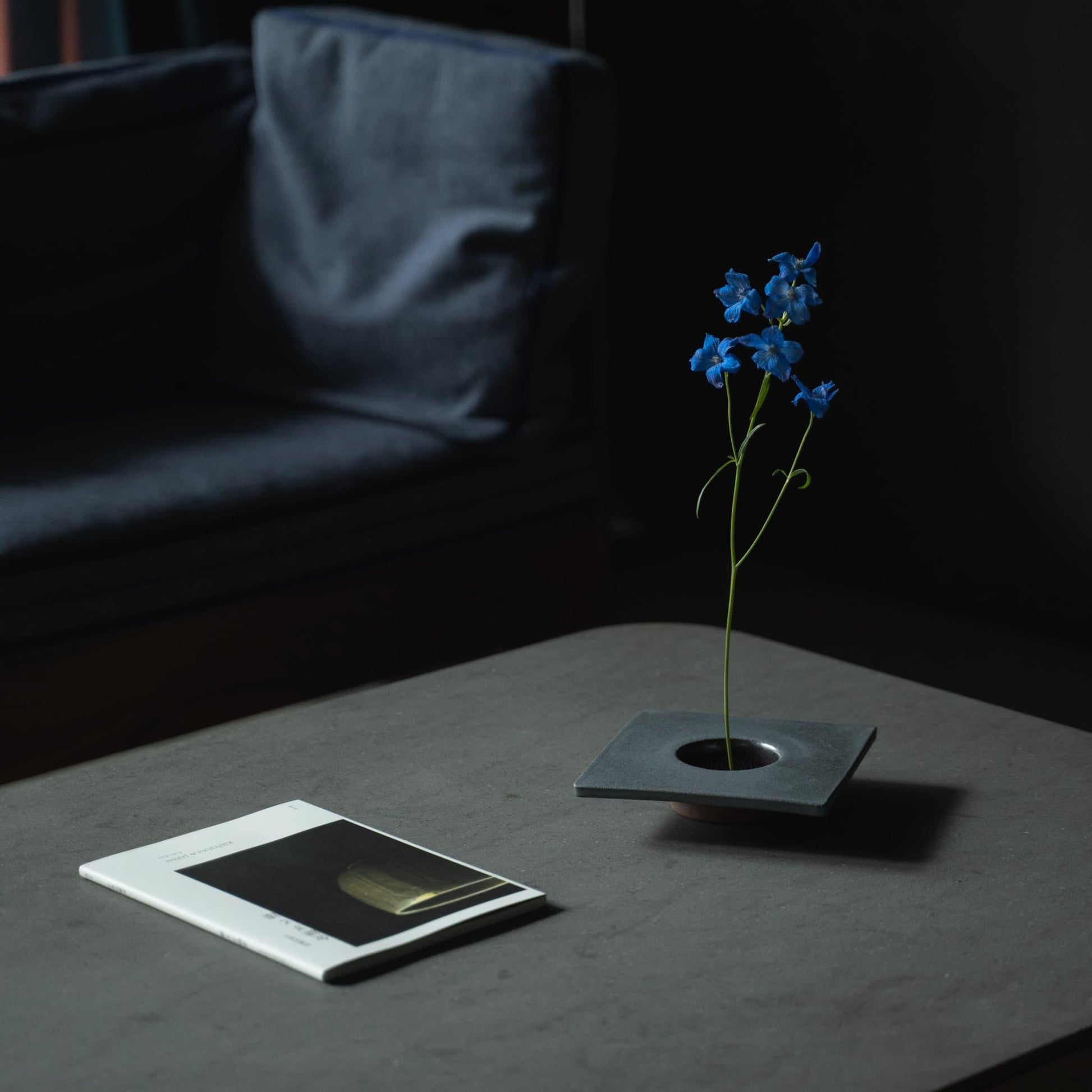 Close-up of a minimalist iron ikebana vase, showcasing the kenzan (flower frog) for arranging flowers.