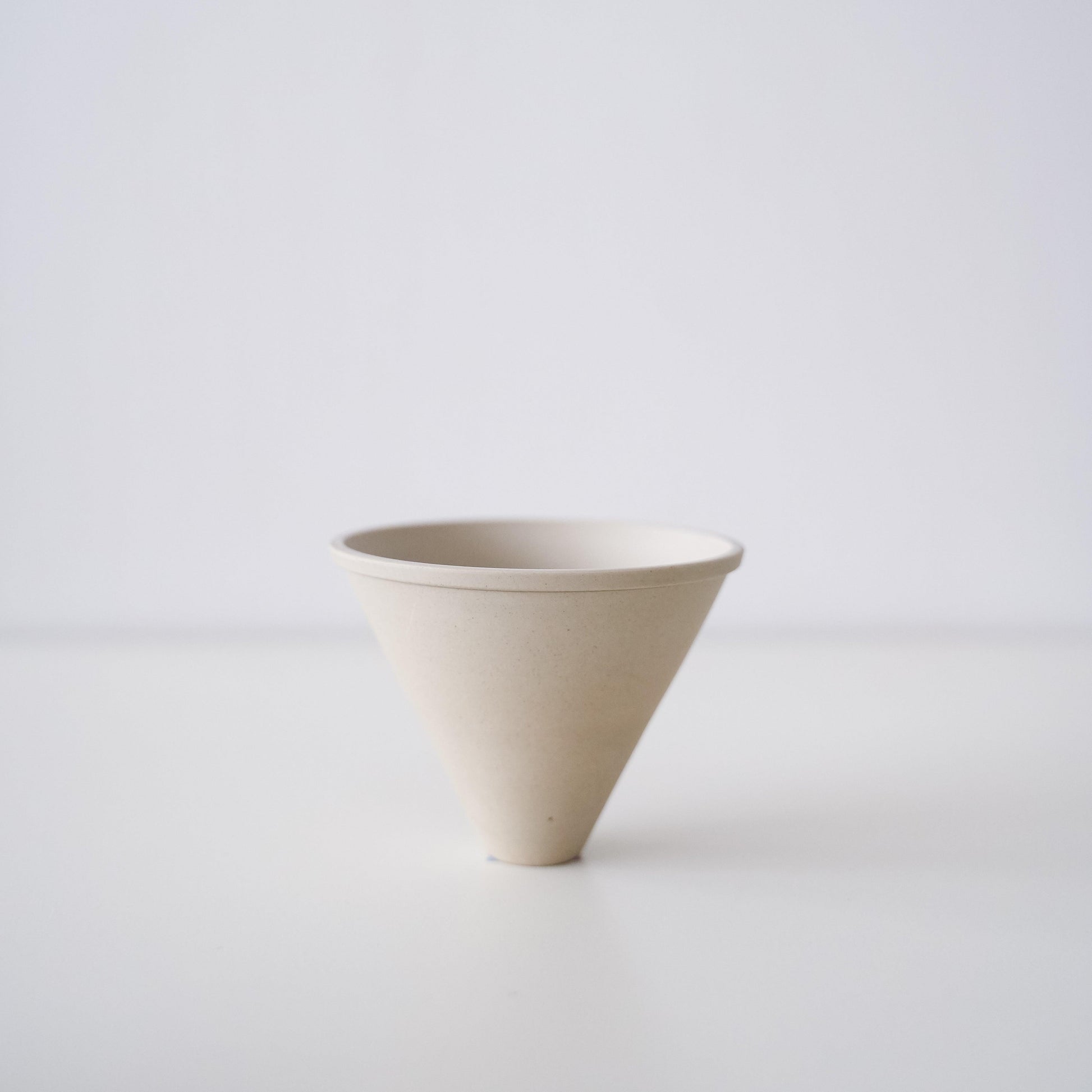 A minimalist white Banko ware coffee dripper.