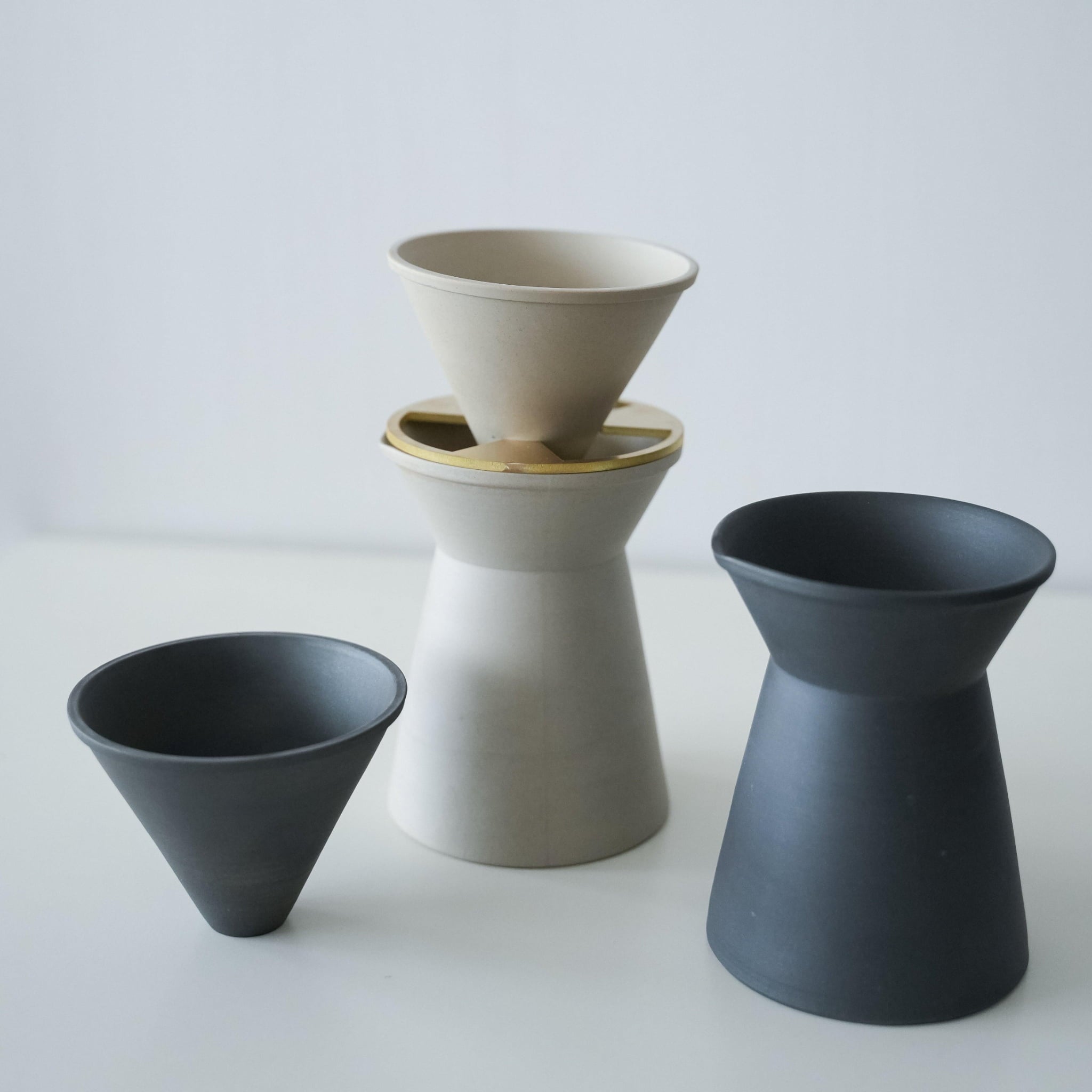 A minimalist white and black coffee server crafted with traditional Japanese Banko-yaki ceramic, featuring a smooth curve and matte finish.