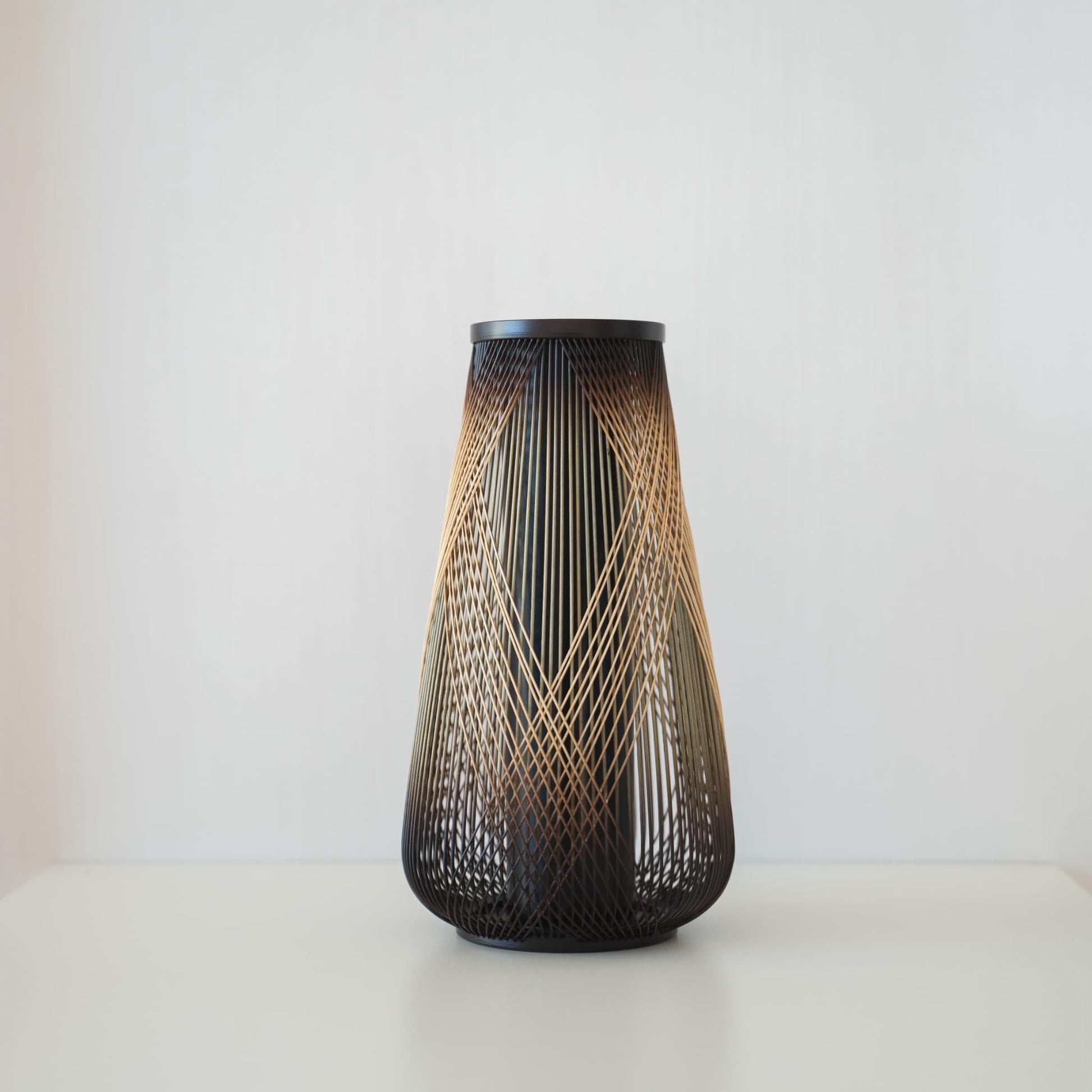 Handcrafted Japanese bamboo Ikebana vase, meticulously crafted by skilled artisans using traditional bamboo weaving techniques, showcasing the natural beauty and elegance of bamboo.