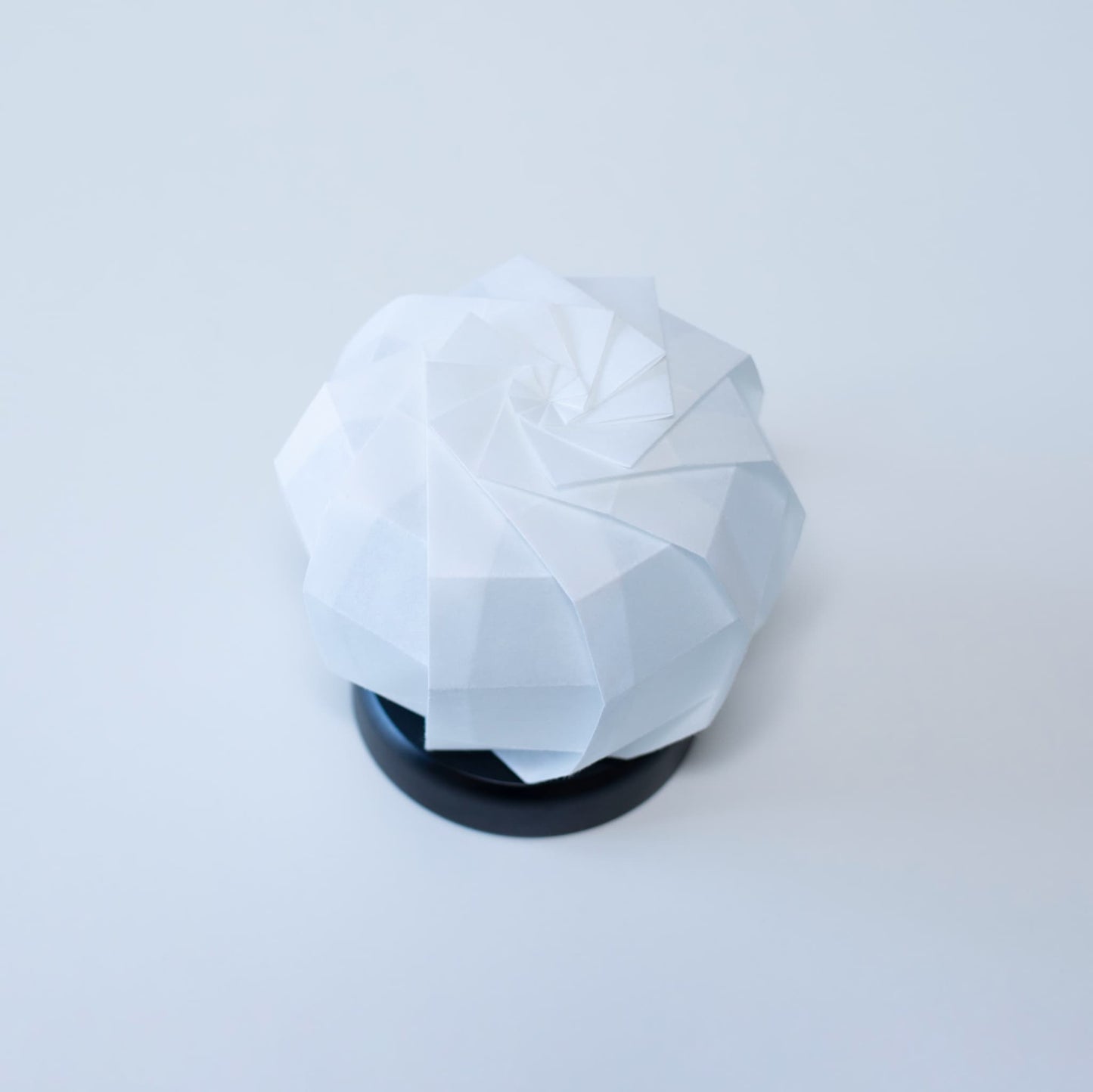 Stylish Origami table lamp with a black base and a white spherical lampshade crafted from textured washi paper.