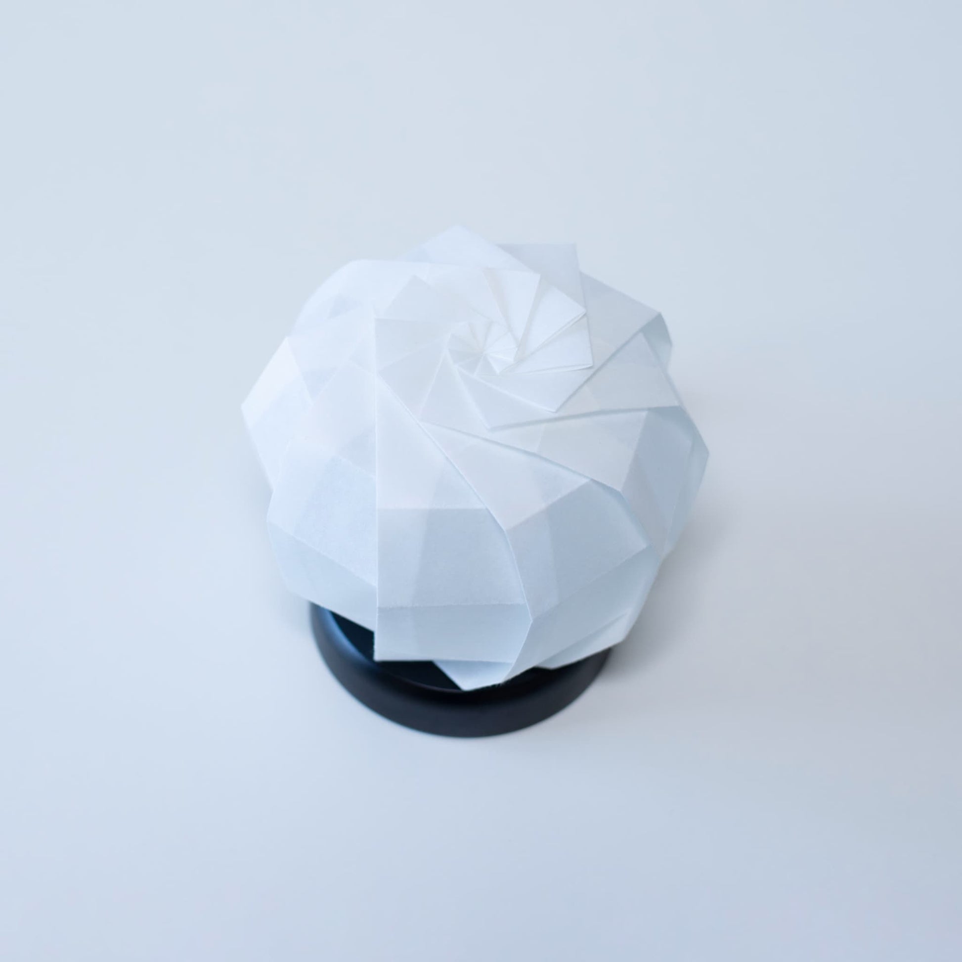 Stylish Origami table lamp with a black base and a white spherical lampshade crafted from textured washi paper.