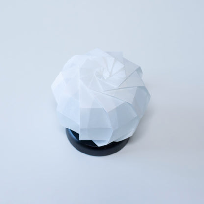 Stylish Origami table lamp with a black base and a white spherical lampshade crafted from textured washi paper.