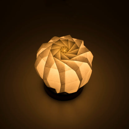Origami Table lamp with a black base and a spherical white lampshade crafted from intricately folded washi paper,  emiting Soft and Warm Light