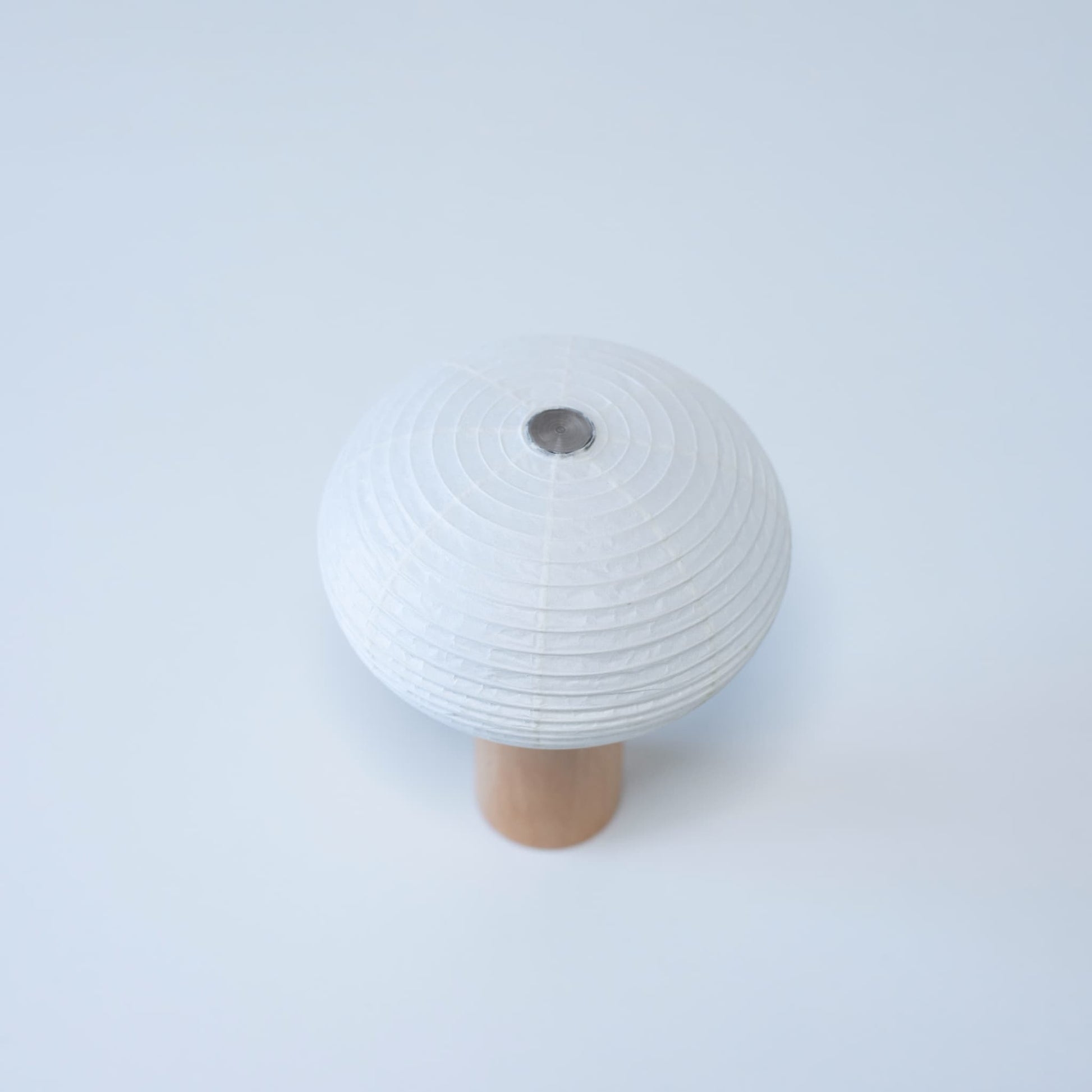 Paper table lamp "TORCHIN OVAL" with a wooden handle and white washi paper shade, handcrafted in Yame, Fukuoka, Japan, known for its traditional Yame lanterns.