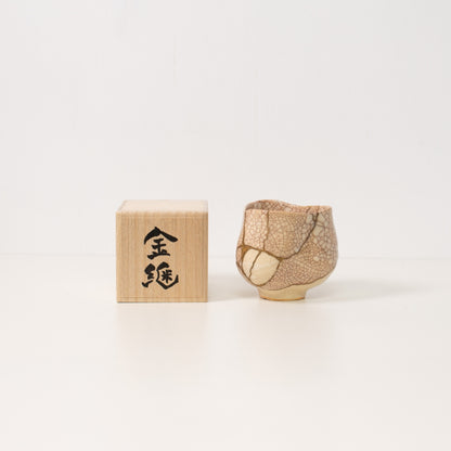 High angle view inside a white crackle kintsugi matcha bowl revealing dramatic golden repairs that embody wabi sabi