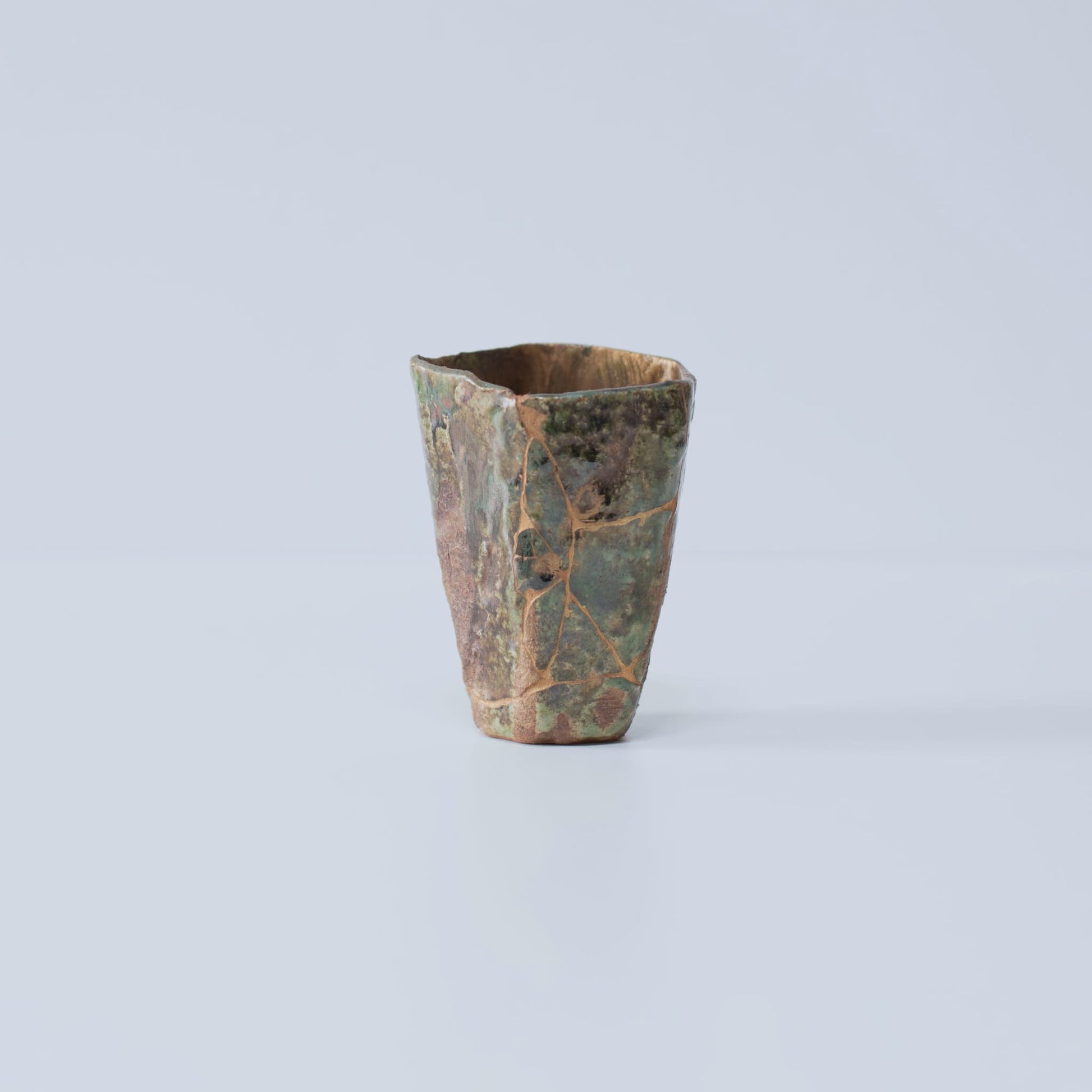 Side view of Pentagon Kintsugi Cup "Oribe" Deep Green 02 against white background