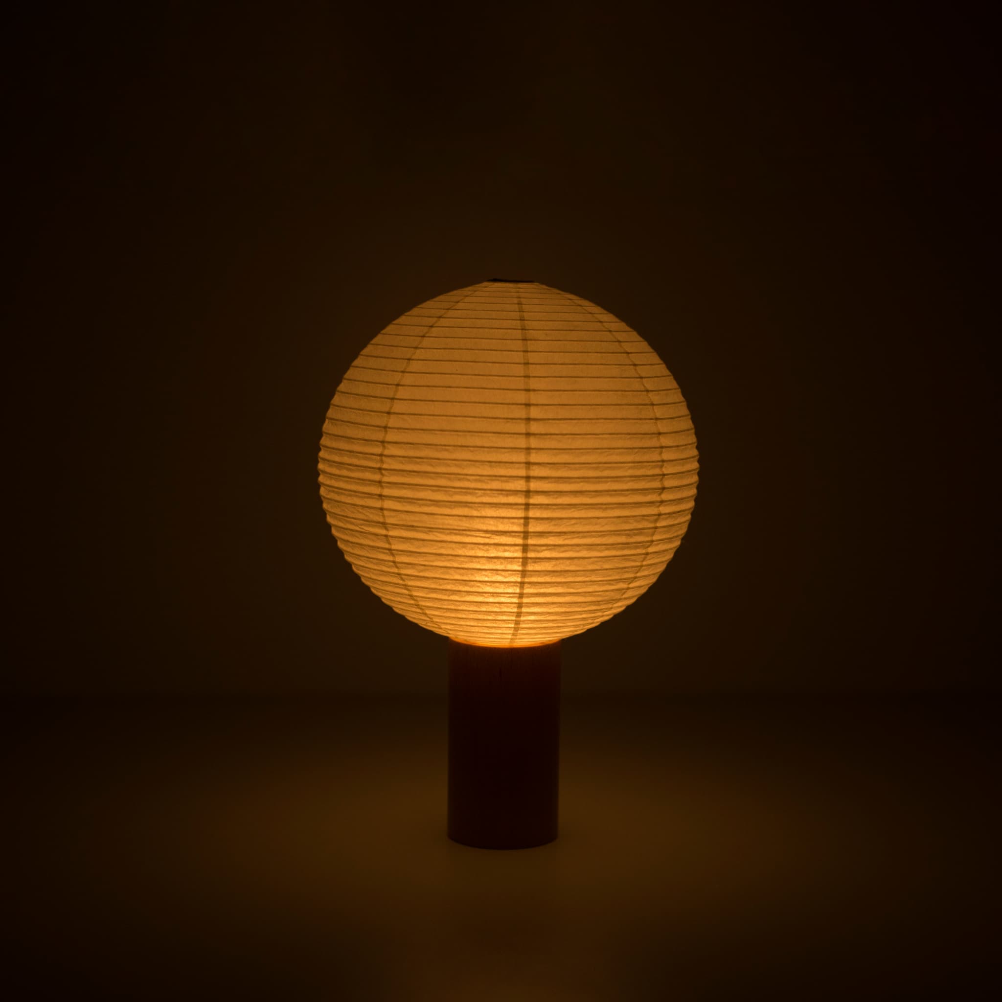 Portable light "TORCHIN CERCLE" emitting a warm glow, handcrafted in Yame, Fukuoka, Japan, known for its traditional Yame lanterns.