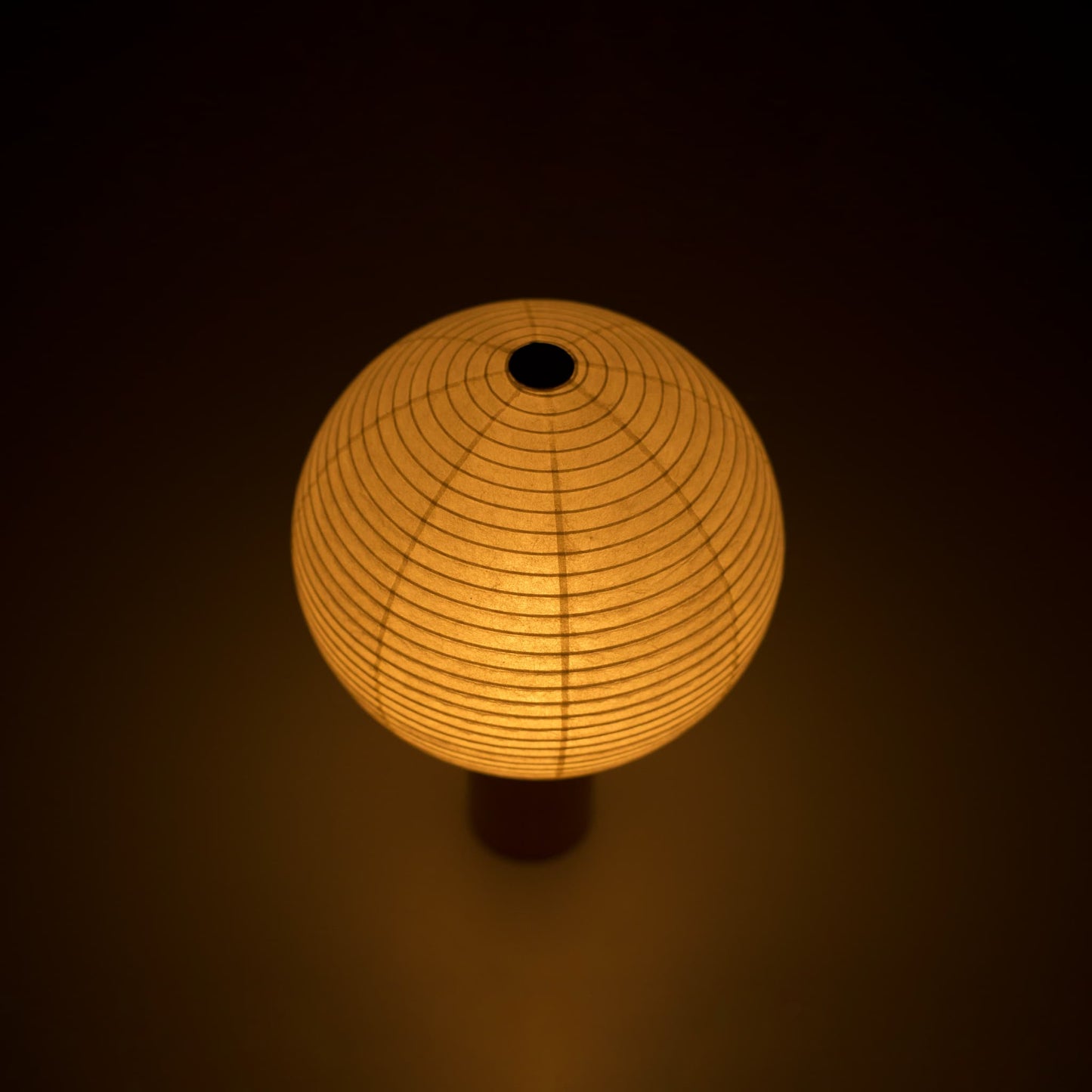 Portable light "TORCHIN CIRCLE" emitting a warm glow, handcrafted in Yame, Fukuoka, Japan, known for its traditional Yame lanterns.