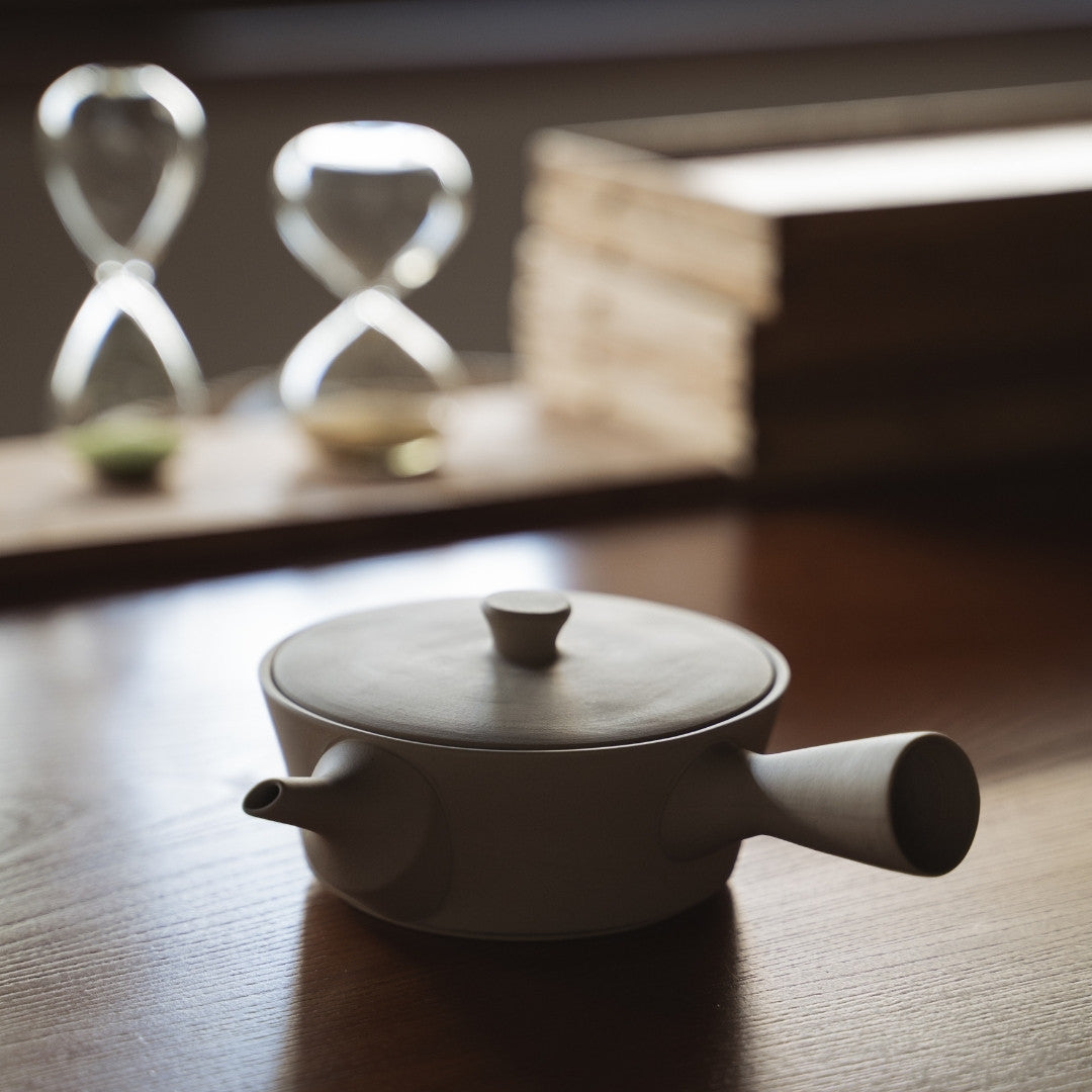 Handcrafted Japanese Sencha teapot white on a wooden table in a zen room 
