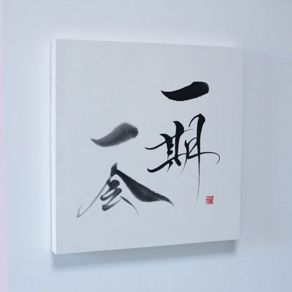 A panel displaying 'Ichigo Ichie' in Japanese calligraphy, mounted on a white wall. 