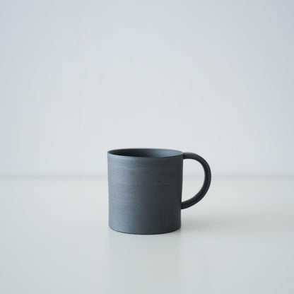 A simple black mug made of traditional Banko ware.