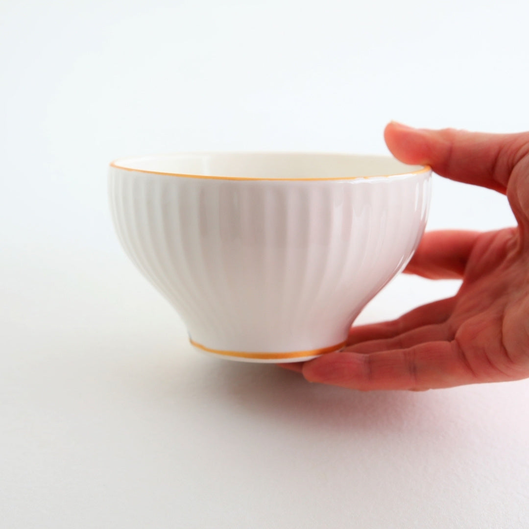 Side view of a handcrafted Japanese matcha bowl “Waraku” with vertical ridges and a warm gold accent, made by Buzan Kiln using traditional Mino Ware techniques.