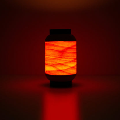 Japanese wood light lamp casting warm reddish glow, inspired by traditional festival lanterns.