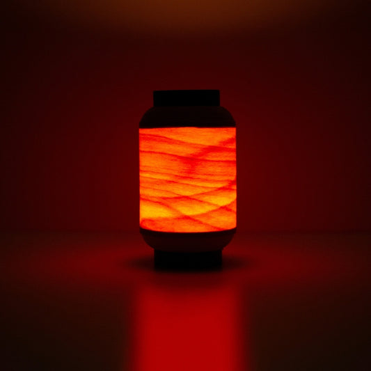 Japanese wood light lamp casting warm reddish glow, inspired by traditional festival lanterns.