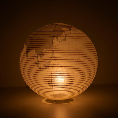 The Japanese Paper Floor Lamp "paper moon 05G" glowing softly, globe-inspired floor lamp