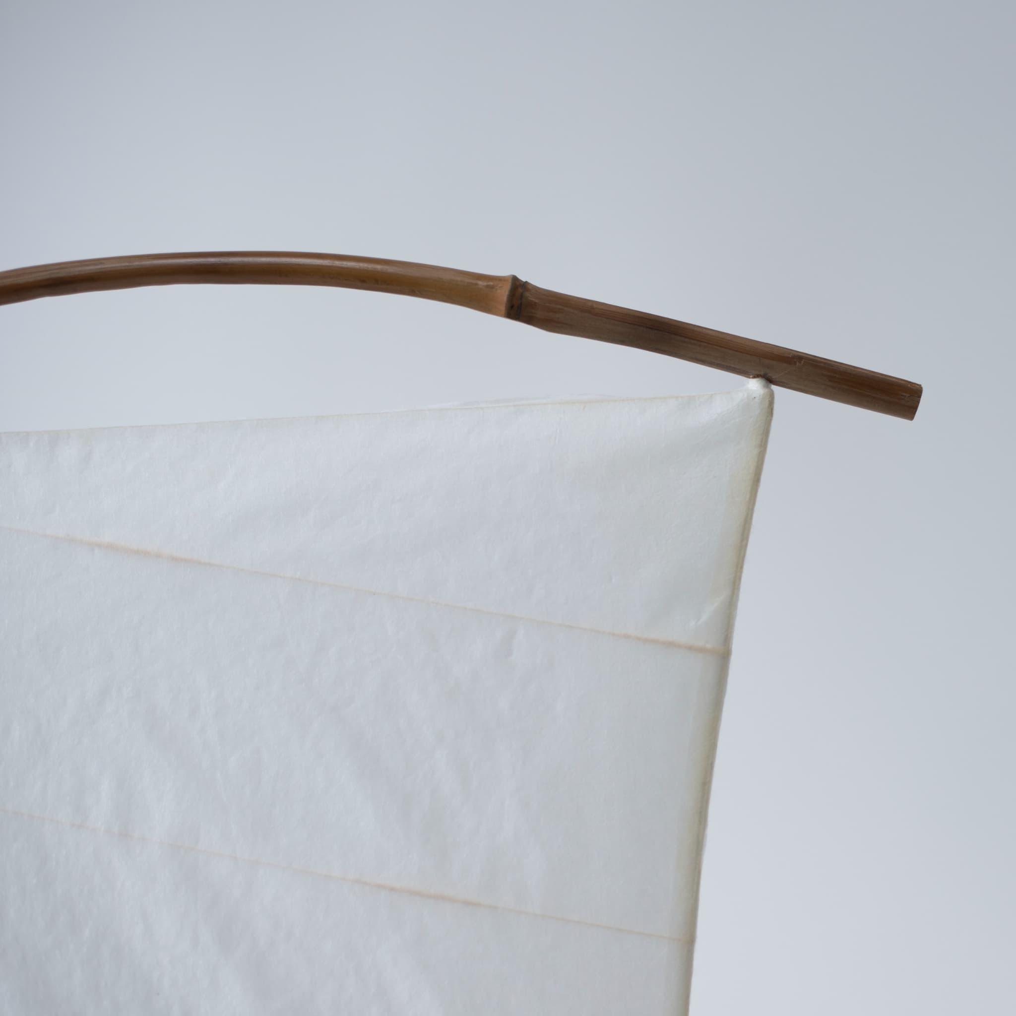Close-up of the top of Japanese Paper Floor Lamp "NOW" against a white background