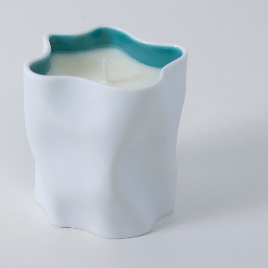Top view of Japanese candle IKEBANA with camellia, violet, and Japanese Incense in ceramic holder