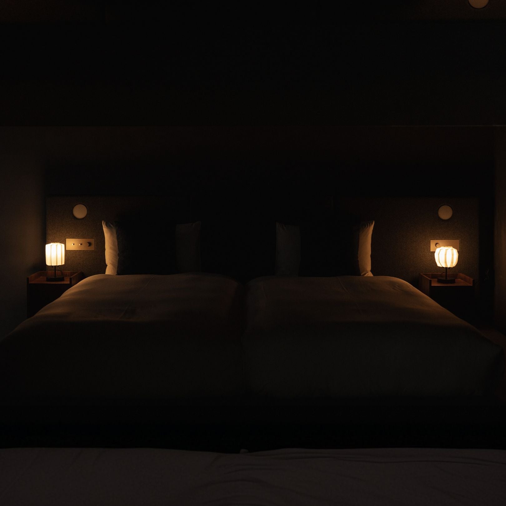 Japanese Paper Table Lamp "Flower of Light" lit on a wooden bedside table