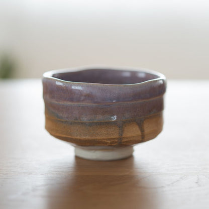 Full view of the wabi sabi style Japanese matcha chawan in Pale Violet Haze, featuring a natural gradient violet glaze over textured earth tones.