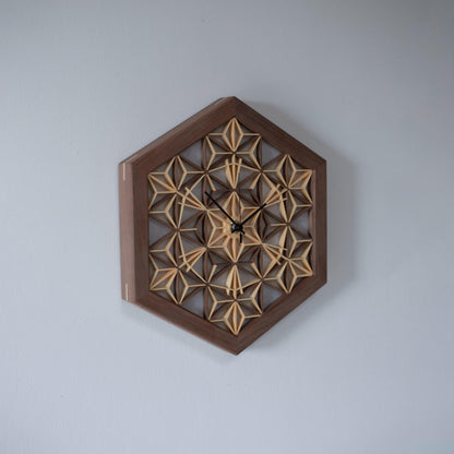 A walnut kumiko clock hanging on a wall, viewed from the left side. The rich color of the walnut wood complements the intricate design.